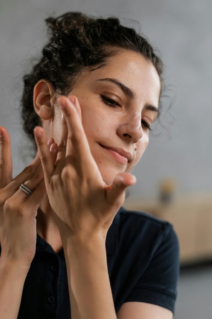 Woman applying skincare product as part of a daily skincare routine