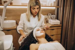 esthetician performing facial treatment on client during skincare training