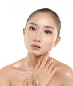 Woman with glowing glass skin demonstrating results of Korean skincare facial techniques