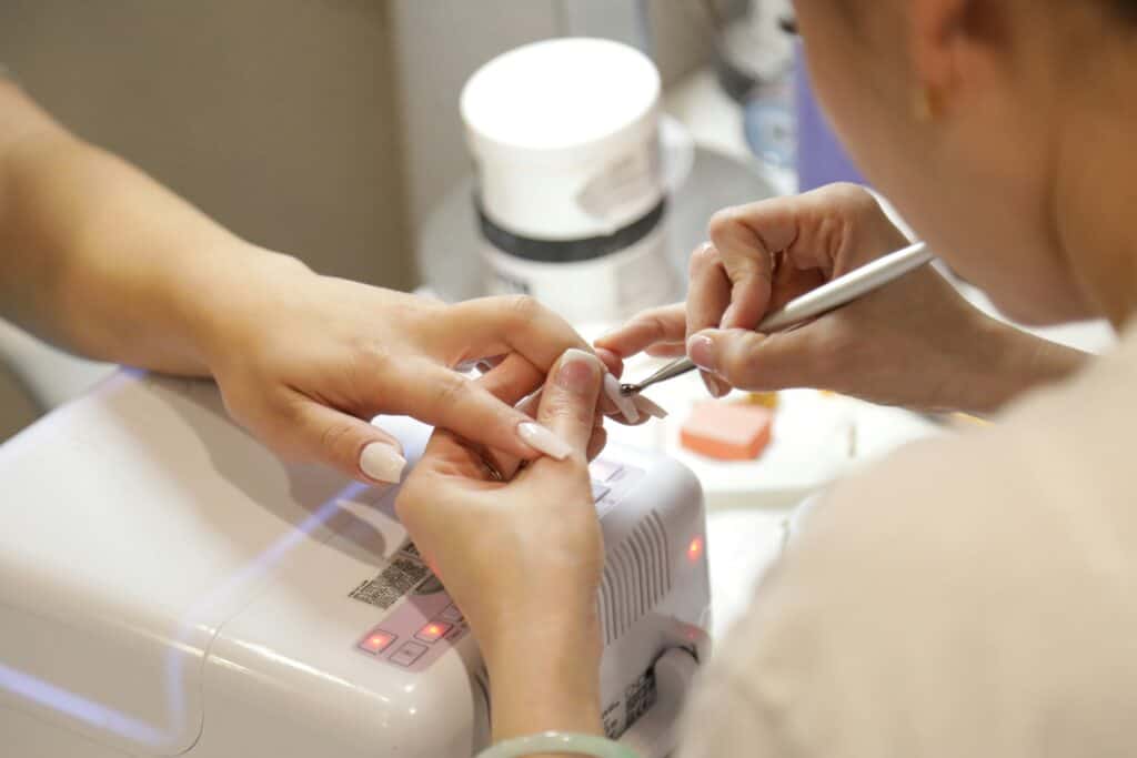 Nail technician performing a professional manicure during hands-on nail technology training in Utah